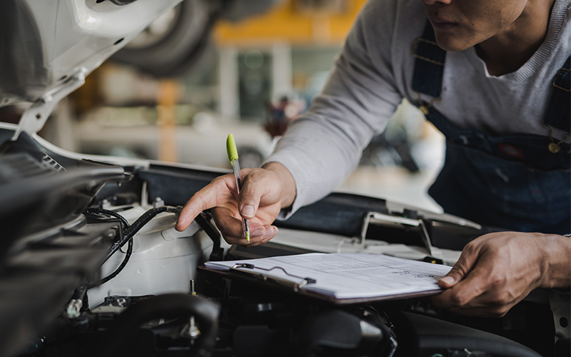 Technician inspecting car engine